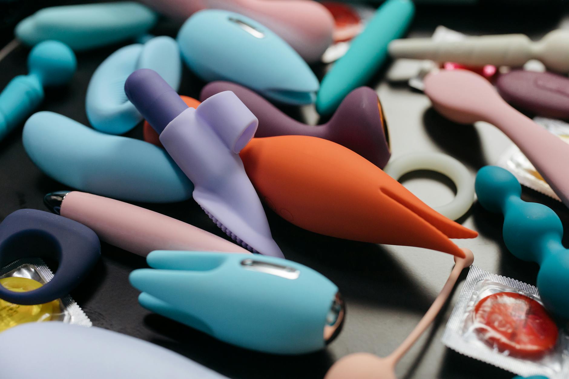 An array of colorful clitoral vibrators and intimate wellness toys arranged on a table