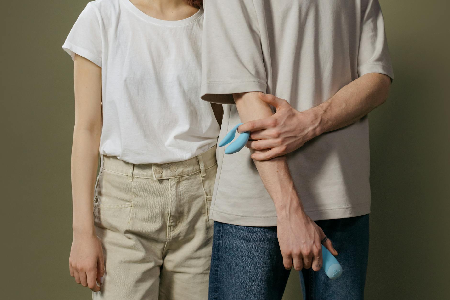 A couple standing together indoors, introducing a lemon vibrator into their intimate moment.